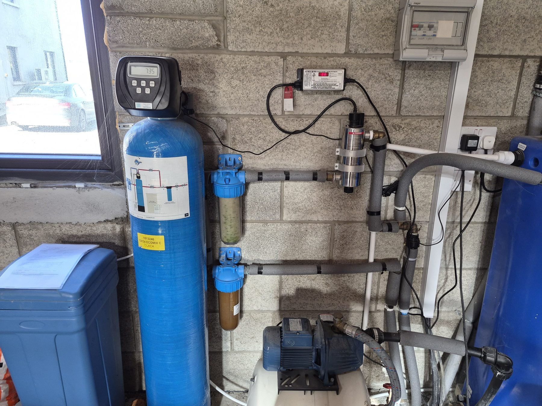 Whole-home water filtration system installed on a supply