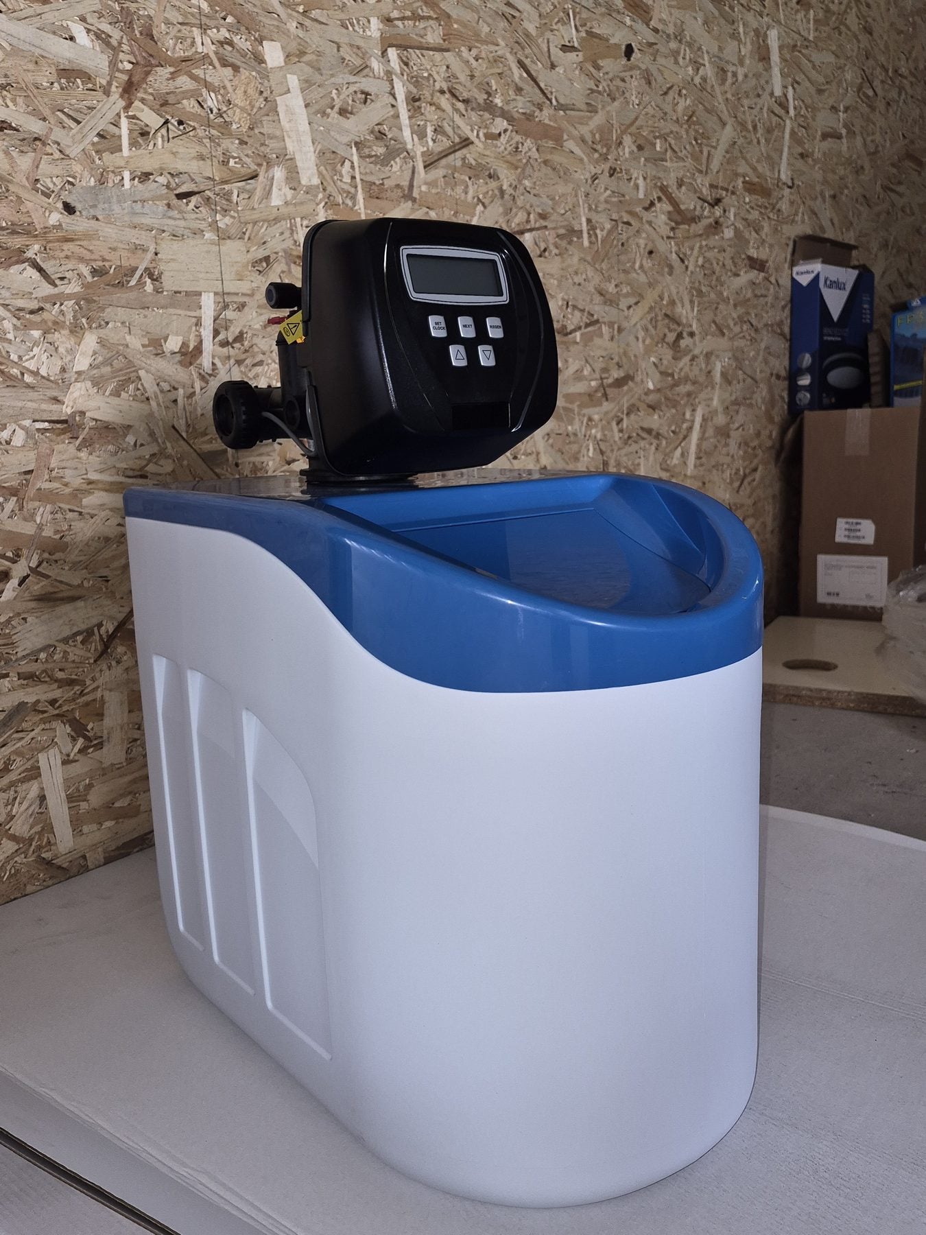 Compact cabinet water softener with a digital control valve in a utility room